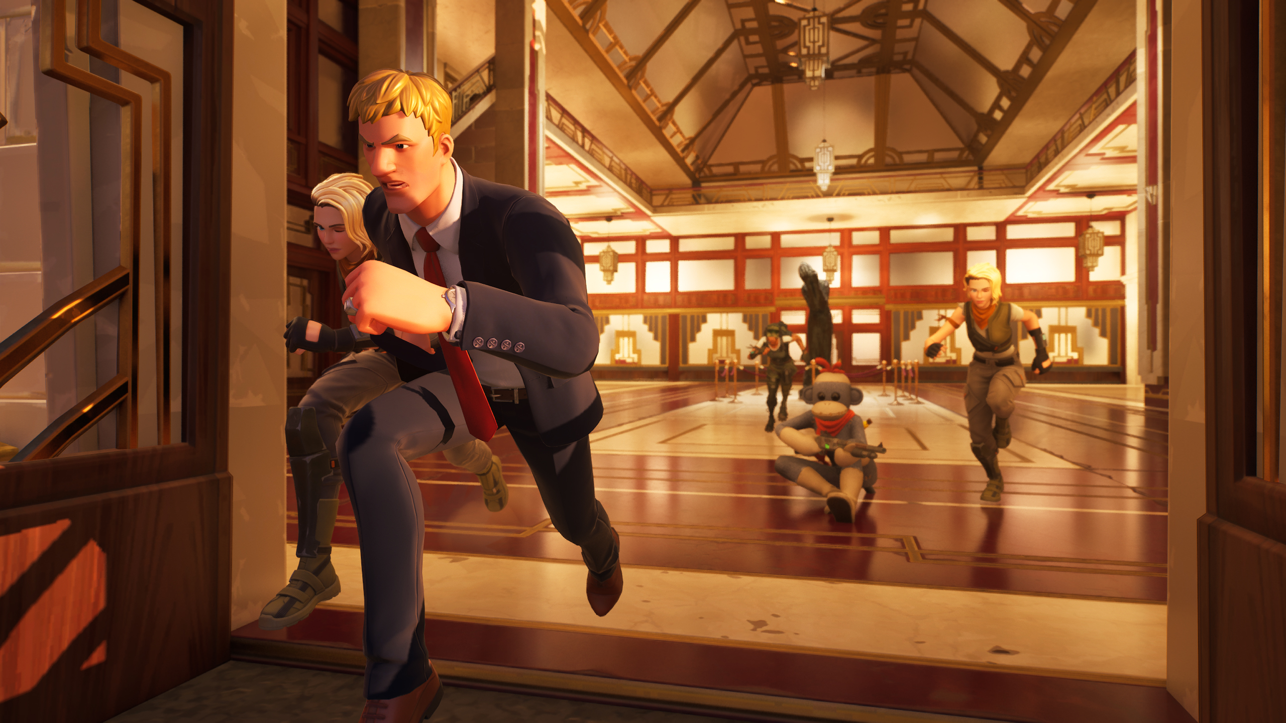 La Galería Nacional de Finlandia se convierte en el primer museo del mundo real incluido en Fortnite Una escena de acción de un videojuego, probablemente Fortnite. En primer plano, se ve a un personaje masculino con traje corriendo y llevando a otro personaje, posiblemente femenino. Detrás de ellos, en un amplio salón con techo alto y columnas, se observan otros personajes en movimiento. El ambiente parece ser el interior de un edificio elegante, posiblemente un museo o una galería de arte, con suelos de madera pulida y una decoración elaborada. La escena transmite una sensación de urgencia y movimiento, típica de una misión de "robo de arte" o una persecución en un juego de acción.