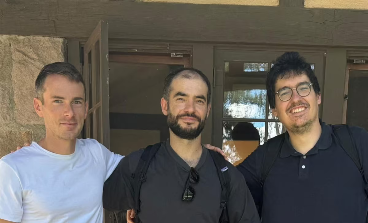 El co-fundador de OpenAI, Sutskever, recauda mil millones en una nueva startup de IA centrada en la seguridad Tres hombres de pie, posando juntos frente a un edificio de piedra y madera. Los tres están sonriendo. El hombre a la izquierda lleva una camiseta blanca, el del centro una camiseta negra con gafas de sol colgadas en el cuello y el de la derecha una camisa negra con gafas redondas. Los tres se ven relajados y amistosos, con los brazos alrededor de los hombros de los demás, en un entorno al aire libre.