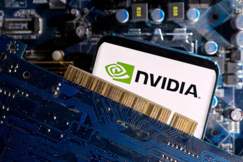 Nvidia supera a Apple como la empresa más valiosa del mundo Primer plano de un circuito electrónico con una tarjeta de video en primer plano y el logotipo de Nvidia en la pantalla de un dispositivo al fondo. La imagen representa el liderazgo de Nvidia en el mercado de tecnología y semiconductores, especialmente en el sector de inteligencia artificial.