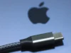 La intervención de la UE en los cargadores de móviles revela el fracaso de las grandes tecnológicas Cable USB-C con diseño trenzado en primer plano, colocado sobre una superficie gris con el logotipo de Apple difuminado al fondo.