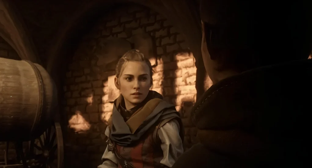 Escena de un videojuego con ambientación medieval: una joven con expresión seria habla con otra persona en una bodega de piedra iluminada por luz cálida.