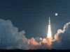 Moonshot AI lanza Kimi K2, modelo open-source que supera a GPT-4 en benchmarks clave Lanzamiento nocturno de un cohete espacial iluminando el cielo entre densas nubes, con la luna visible al fondo. La escena transmite un momento épico de exploración y avance tecnológico.