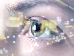 Científicos desarrollan corrección visual sin láser usando corriente eléctrica para remodelar la córnea Primer plano de un ojo humano con reflejos brillantes de luces de ciudad superpuestos, simbolizando tecnología, percepción aumentada o visión futurista. El iris muestra detalles en tonos verdes y dorados, con enfoque en la pupila y las pestañas.