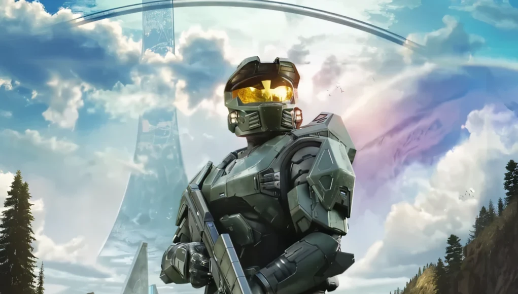 Halo MMO Personaje de ciencia ficción con armadura verde futurista y visor dorado, sosteniendo un arma. Está de pie en un paisaje montañoso con estructuras metálicas gigantes en forma de anillo al fondo y cielo parcialmente nublado. La escena pertenece al universo del videojuego Halo.