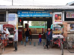 El pueblo indio que transformó las estafas telefónicas en una industria multimillonaria Entrada a la estación de tren de Jamtara, con un cartel que dice “Welcome to Jamtara Station” en inglés e hindi. Frente al acceso hay varias personas, rickshaws estacionados y vendedores locales.
