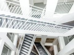 Las palabras del año revelan el estado deplorable de internet y las redes sociales Vista cenital de un interior arquitectónico moderno con múltiples tramos de escaleras blancas y barandillas geométricas que se cruzan en distintos niveles, creando un patrón abstracto y simétrico de líneas y formas.